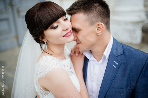 Bride and groom at wedding Day walking Outdoors near architecture. Bridal couple, Newlywed woman and man embracing with love © deineka