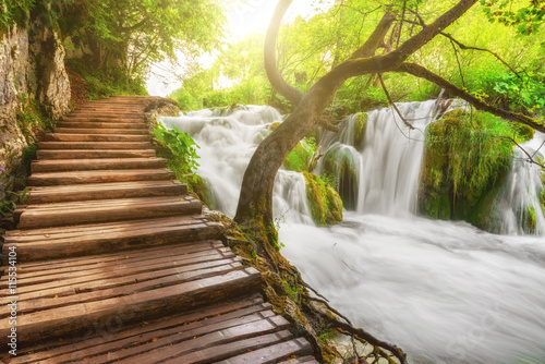 Plitvice Lakes National Park, tourist route on the wooden flooring along the waterfall, Croatia, nature sunny background