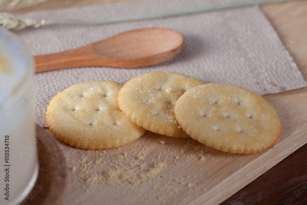 close up biscuits with hot milk on wooden plate on wooden table close up biscuits with hot milk on wooden plate on wooden table
