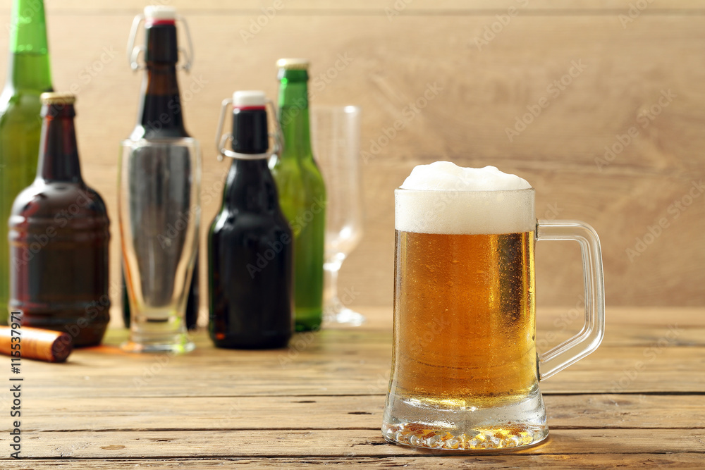 boccale di birra chiara con bottiglie sullo sfondo boccale di birra chiara con bottiglie sullo sfondo