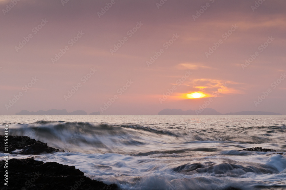 The sunset over the sea with waves