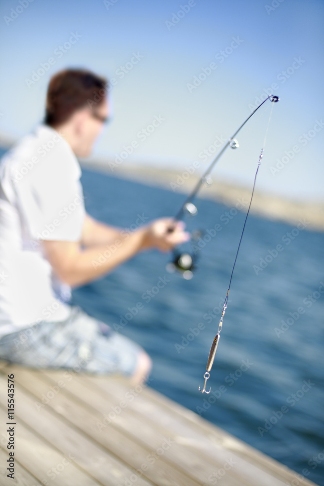 Sweden, Bohuslan, Tjorn, Man fishing from jetty Sweden, Bohuslan, Tjorn, Man fishing from jetty