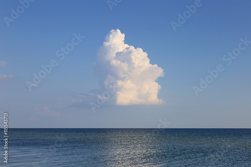 Alone clouds over seascape. Billowing cumulus cloud summer day.