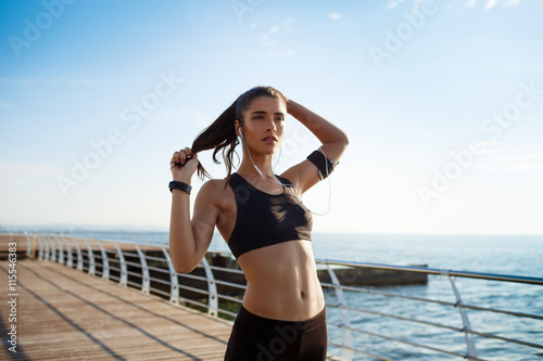 Picture of young attractive fitness girl running with sea coast on background © Cookie Studio