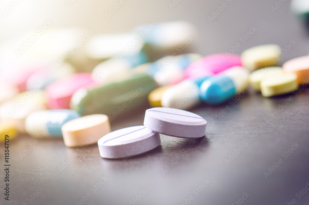 Pharmacy background on a black table. Tablets on a black background. Pills. Medicine and healthy. Close up of capsules. Differend kind of pills. Sunlight on the left corner of picture Pharmacy background on a black table. Tablets on a black background. Pills. Medicine and healthy. Close up of capsules. Differend kind of pills. Sunlight on the left corner of picture