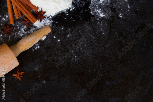 raw baking ingredients - flour and spices on black background with copy space