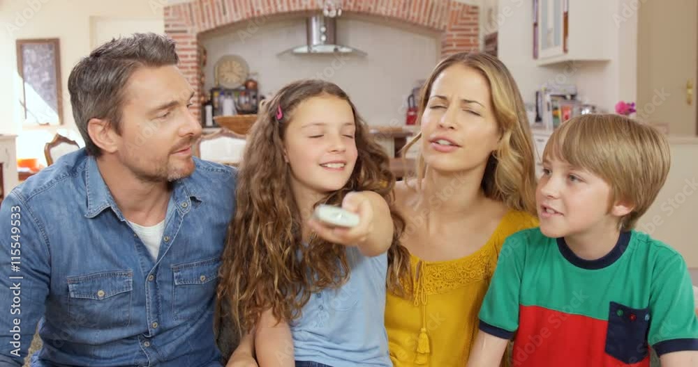 Happy family using remote on the sofa Happy family using remote on the sofa