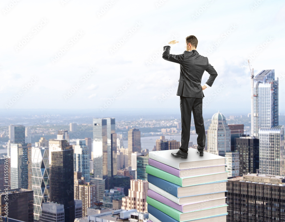 businessman standing on stack of books businessman standing on stack of books