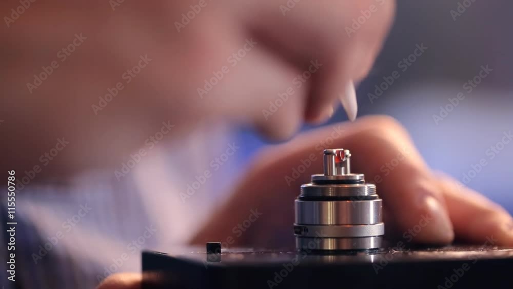 Process of burning a new microcoil on base of clearomizer, incandescence wire closeup. Process of burning a new microcoil on base of clearomizer, incandescence wire closeup.