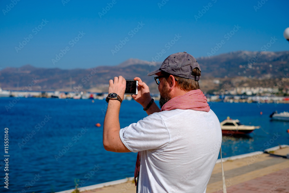 Obraz premium Young man doing selfie on the beach