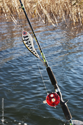 Sweden, Smaland, Hasselo, Close up of fishing rod, water in background photo