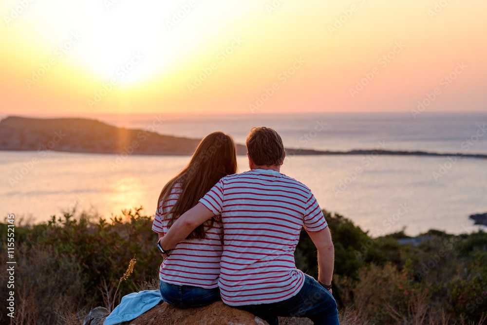 Romantic of couple love sitting on the stone looking sunset at mountain