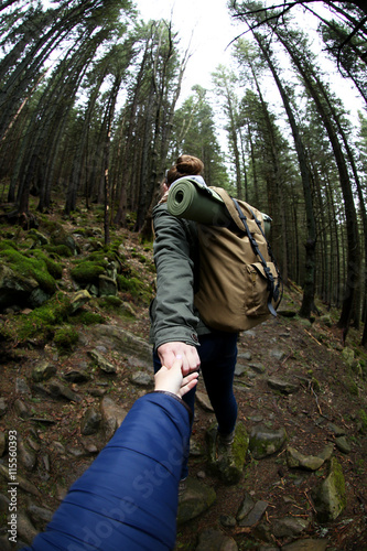 Two tourists walking in mountain forest