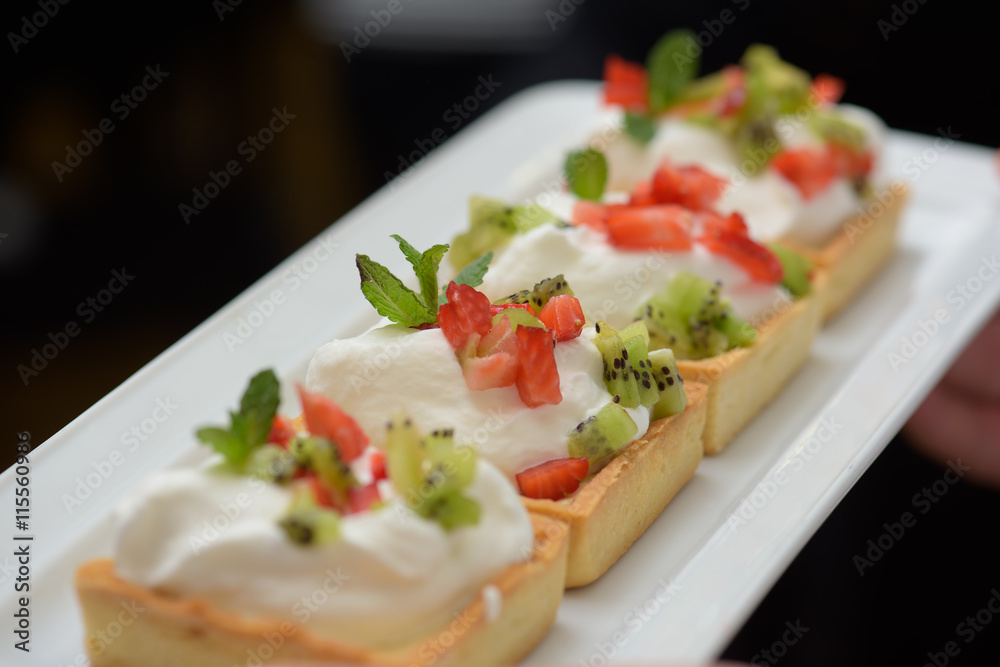 Tarts with whipped cream and strawberries and mint leaves Tarts with whipped cream and strawberries and mint leaves