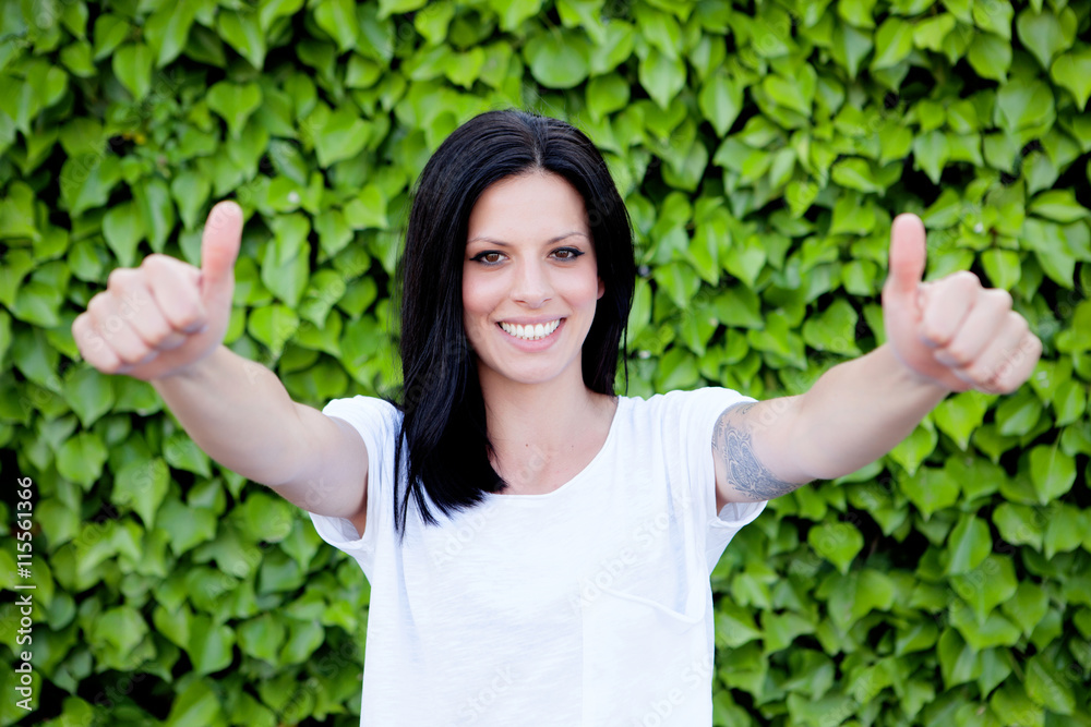 Cool brunette girl saying Ok with thumbs up