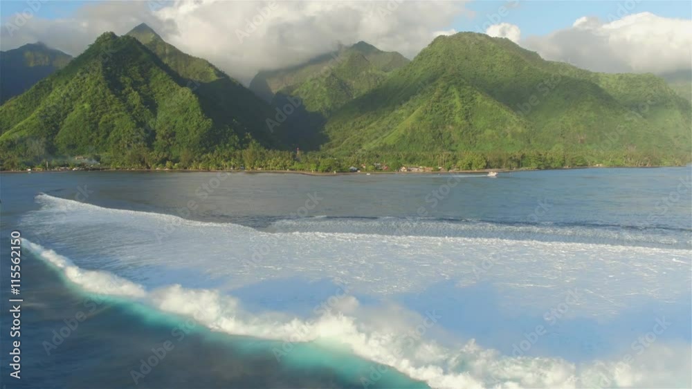 AERIAL: Big Teahupoo wave breaking and rolling towards Tahiti island