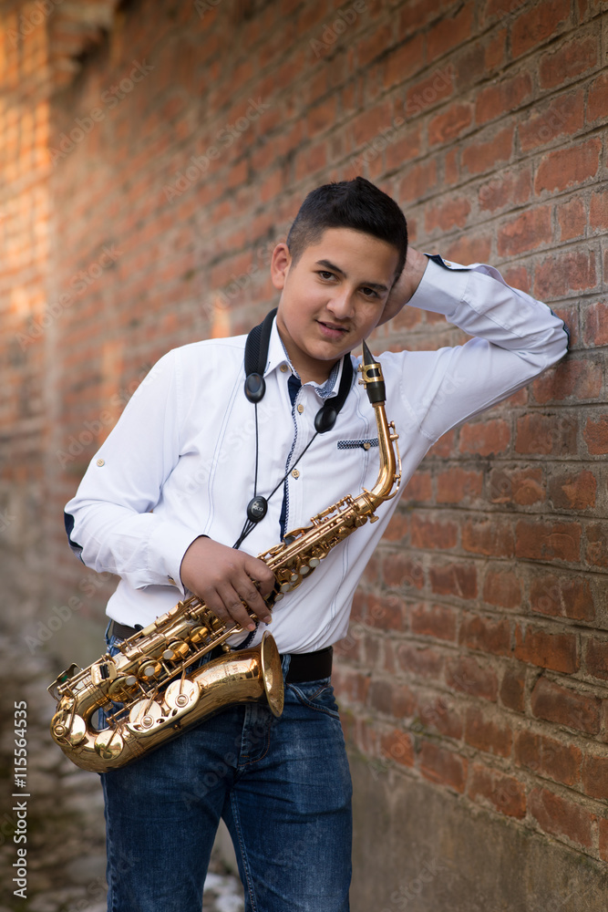 Young gypsy saxophone player.Colored and under exposed photo