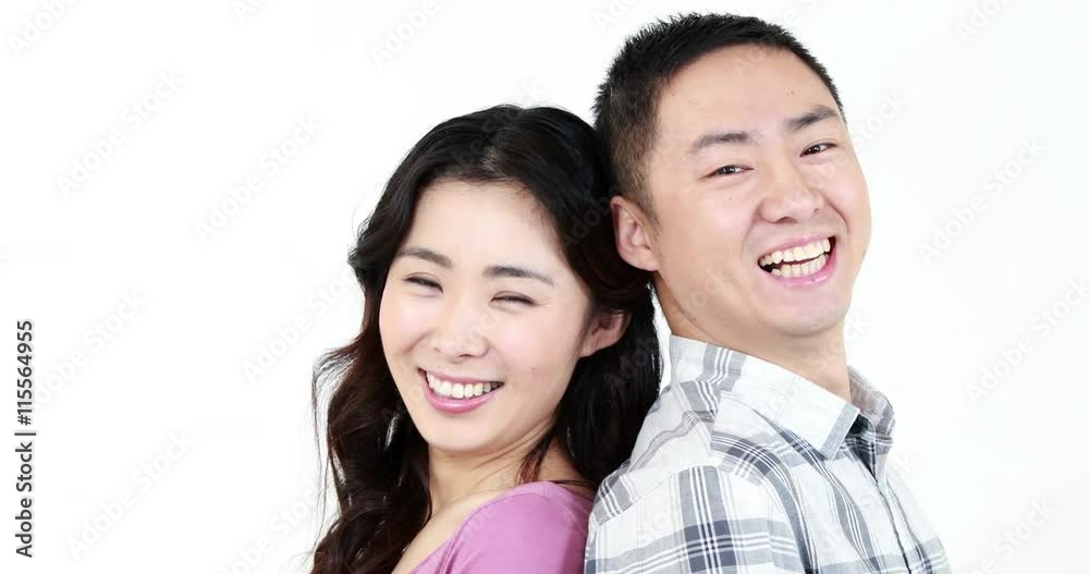 Smiling couple showing their thumbs at the camera on white screen Smiling couple showing their thumbs at the camera on white screen