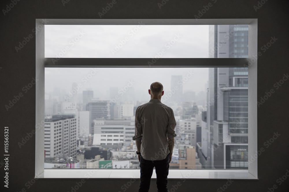 Japan, Tokyo, Shibuya, Man looking at cityscape through window Japan, Tokyo, Shibuya, Man looking at cityscape through window