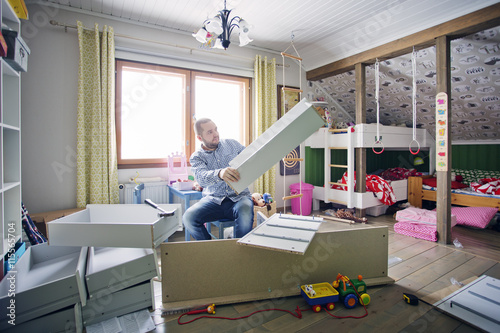 Finland, Man building cabinet in nursery photo