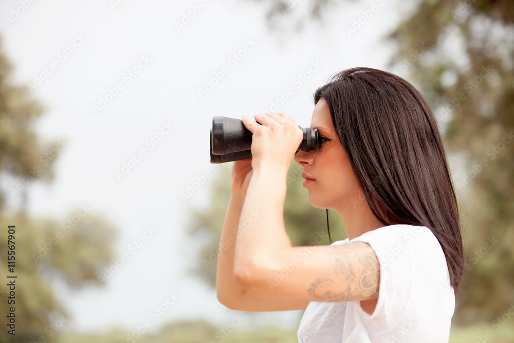 Brunette woman looking through binoculars