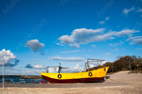 Fototapeta Naklejka Na Ścianę i Meble -  Yellow fishing boat moored on the beach