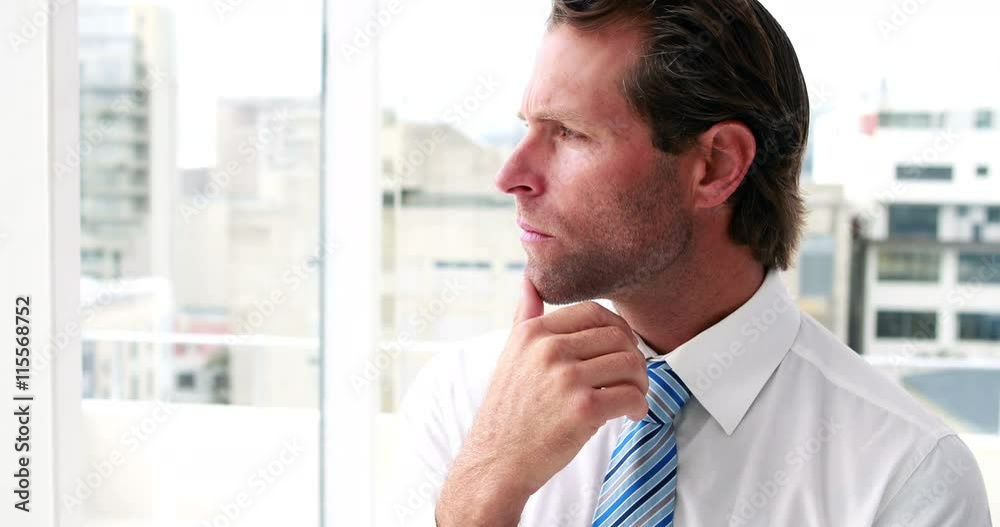 Handsome businessman thinking and looking out window in the office Handsome businessman thinking and looking out window in the office
