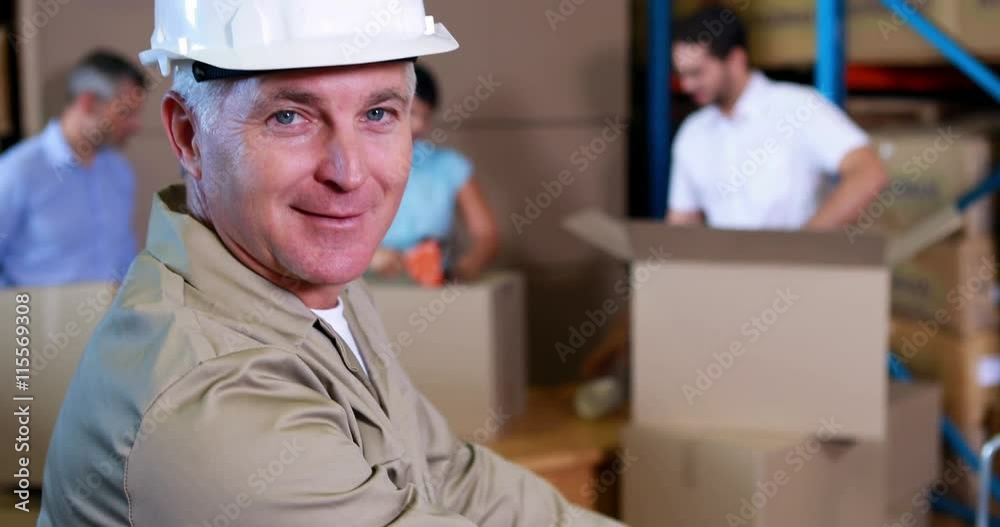 Warehouse worker stacking boxes and smiling at camera Warehouse worker stacking boxes and smiling at camera