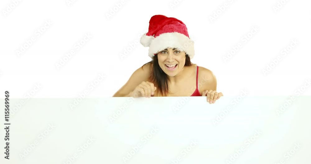 Beauty brunette in santa hat showing white poster on white background Beauty brunette in santa hat showing white poster on white background