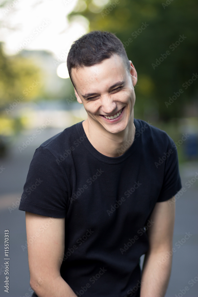 Young man in early 20s laughing smiling Young man in early 20s laughing smiling