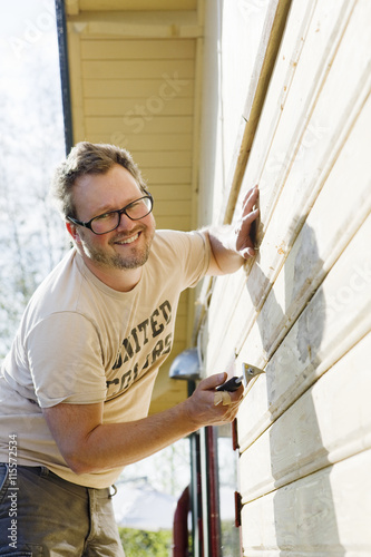 Wallpaper Mural Sweden, Vastra Gotaland, Portrait of home owner repairing wall of house Torontodigital.ca