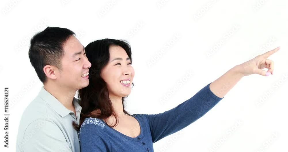 Happy couple pointing something on white screen Happy couple pointing something on white screen