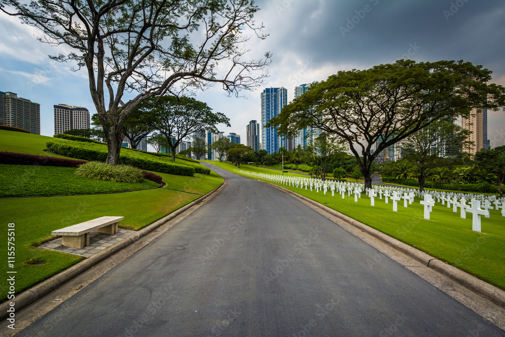 Road and graves with modern buildings in the distance at the Man
