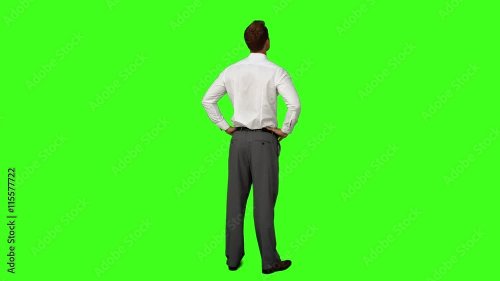 Businessman standing with hands on hips on green screen background Businessman standing with hands on hips on green screen background