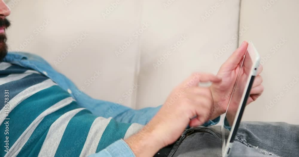 Casual businessman using tablet pc on couch in high quality 4k format