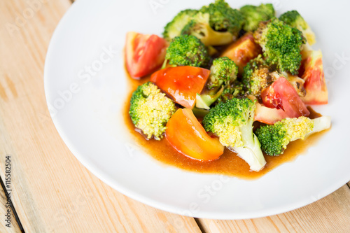 tomatoes and broccoli stir-fry. in plate on table