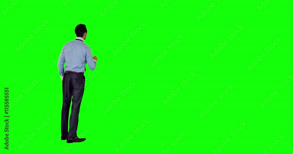 Rear view of businessman scrolling green screen 