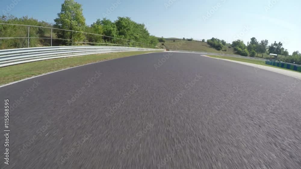 LOW ANGLE VIEW: Race car competing and driving fast on race track lap