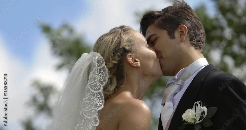 Laughing newlyweds kissing outside on a windy day Laughing newlyweds kissing outside on a windy day