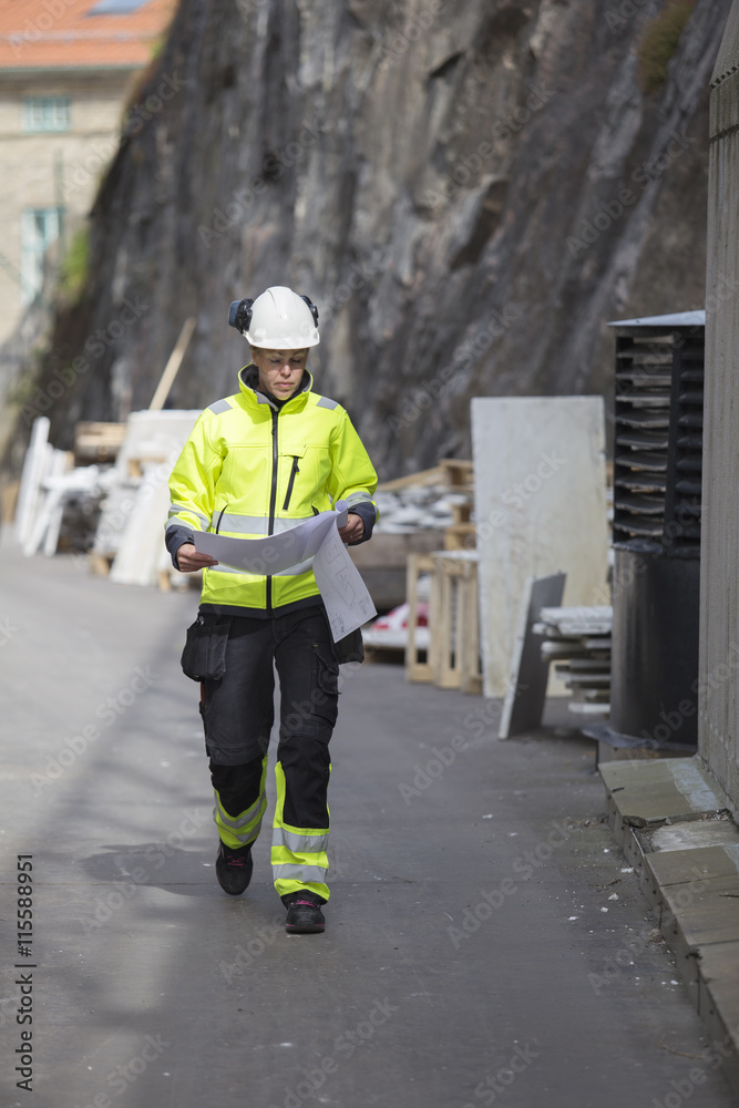 custom made wallpaper toronto digitalConstruction worker reading blueprints while walking at construction site