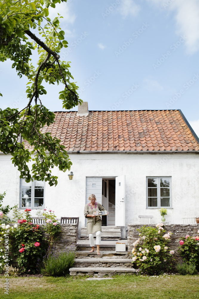 Woman walking down steps in front of house Woman walking down steps in front of house