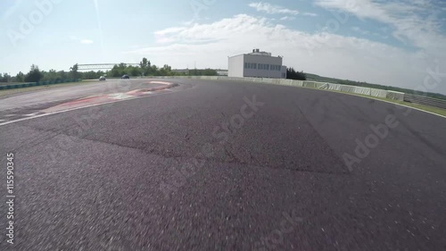 LOW ANGLE VIEW: Race car competing and driving fast on race track lap photo