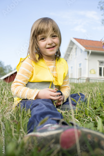 Sweden, Vastergotland, Olofstorp, Bergum, Portrait of girl (4-5) sitting in grass photo