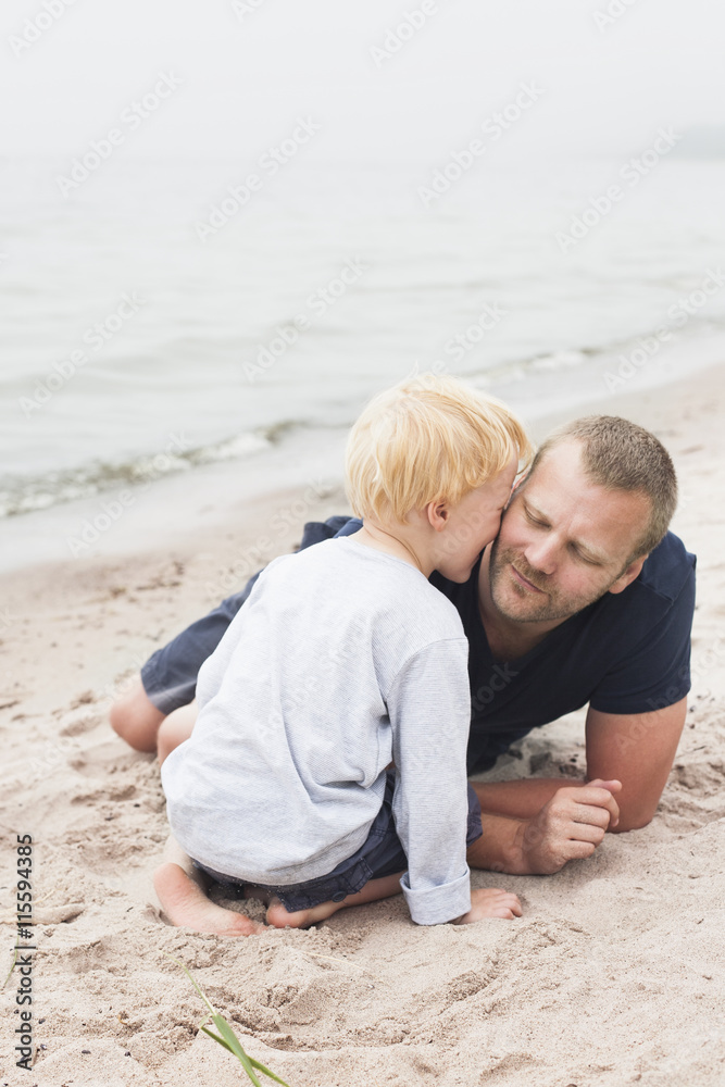 Sweden, Gotland, Ljugarn, Boy (4-5) kissing man on chick Sweden, Gotland, Ljugarn, Boy (4-5) kissing man on chick