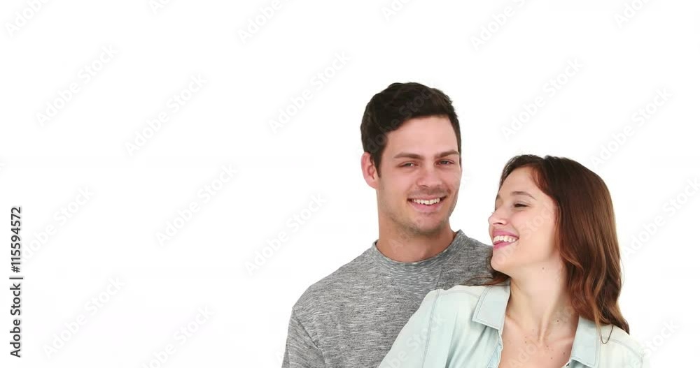 Smiling couple pointing away and embracing on white background Smiling couple pointing away and embracing on white background