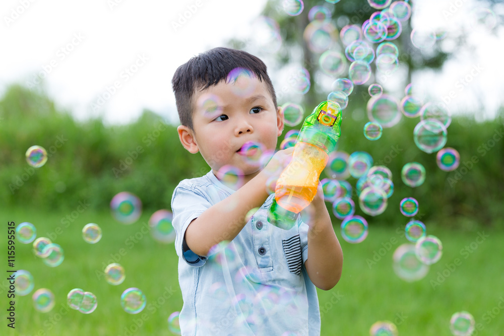 Little child play with bubble blower gun
