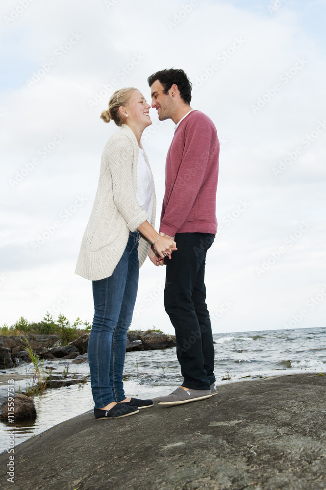 Sweden, Vastra Gotaland, Kallandso, Young couple holding hands on lakeshore Sweden, Vastra Gotaland, Kallandso, Young couple holding hands on lakeshore