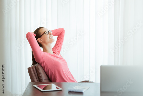 Woman thinking and relaxing in her office.