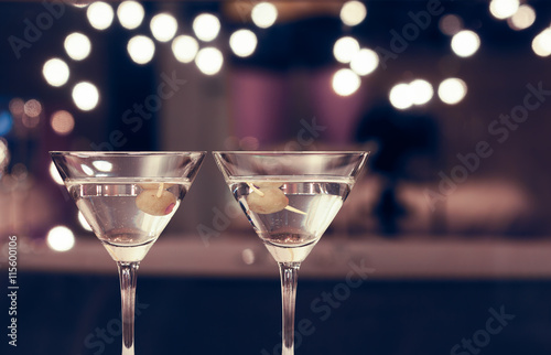 Pair of martini glasses on restaurant bar. 