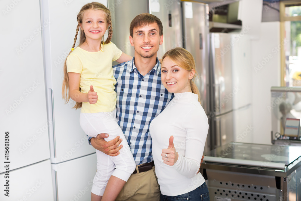 Obraz premium Parents with daughter in home appliance store